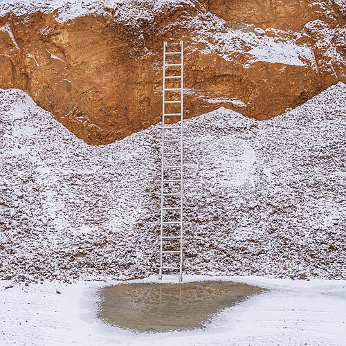 A metal ladder in the building pit for a bank building in Hof, Bavaria, with a little snow.