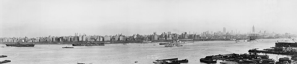 Panorama of Manhattan's West Side from Across the Hudson, celebrating Navy Day and the end of the Second World War, showing ships at harbor including the U.S.S. Midway, the largest ship in the world at the time. Vintage silver gelatin photograph.
